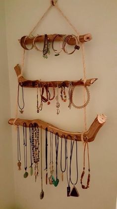 a wall hanging with various necklaces and bracelets attached to the side of it