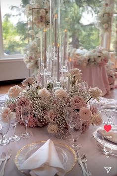 the table is set with flowers, candles and wine glasses for an elegant wedding reception