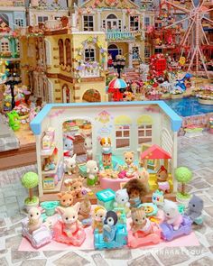 there are many stuffed animals in front of a toy house with toys on the ground