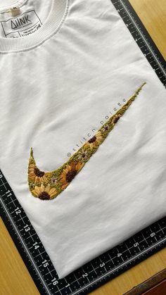 a white t - shirt with sunflowers on it