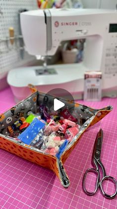 scissors and sewing supplies sit on a pink table