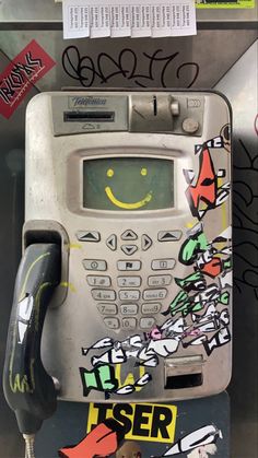 an old pay phone with graffiti on it