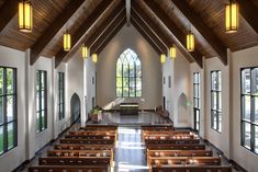 an empty church with pews and stained glass windows