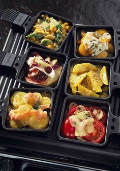 a black tray filled with different types of food on top of a grilling pan