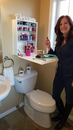 a woman taking a selfie in front of a bathroom sink with the word dream written on it