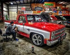 a man working on a red truck in a garage