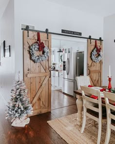 a christmas tree sits in the middle of a dining room table with two wreaths on it