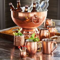 a large copper bowl filled with bottles and glasses