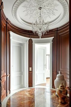 an elegant foyer with marble flooring and chandelier hanging from the round ceiling