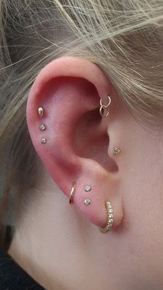 a close up of a person's ear with three different types of piercings