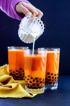 someone is pouring orange juice into two glasses with the words easy thai bubble tea on top