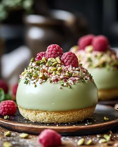 two desserts with raspberries and pistachio on top