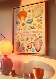 there is a framed poster on the wall next to a lamp and other items in front of it