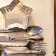 silverware is displayed on a wall with a star shaped plate and spoons in it