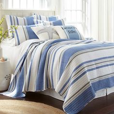 a bed with blue and white bedspread in a room