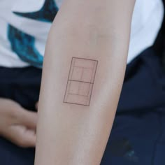 a person with a tattoo on their arm that has a square and rectangle in it