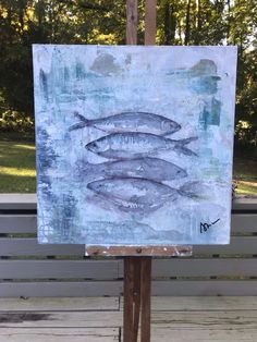 an easel with a painting of fish on it