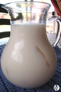 a pitcher of milk sitting on top of a table