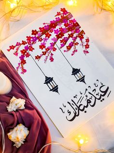 an arabic greeting card with flowers and lanterns