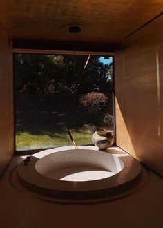 the inside of a room with a large round tub in front of a glass window