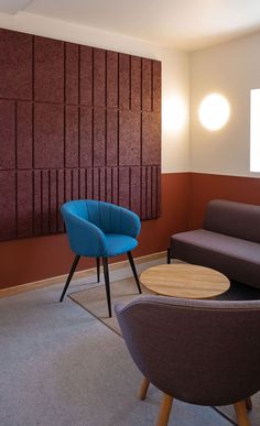 two chairs and a table in a room with wood paneling on the wall behind them