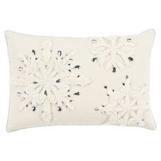 an embroidered pillow with snowflakes on the front and back, in white linen