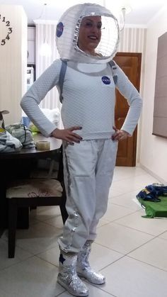 a man in white space suit standing next to a table