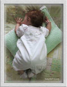 a baby laying on top of a green blanket