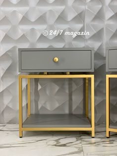 two grey and gold nightstands side by side against a wall with geometric tiles on it