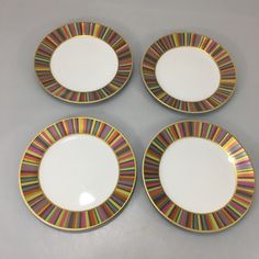 four plates with multicolored stripes on them