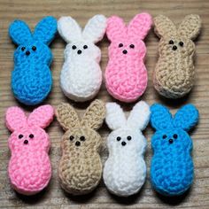 small crocheted bunnies in different colors and sizes on a wooden table top