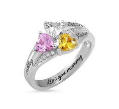 two heart shaped rings with names engraved on the sides and three stones in each ring