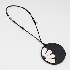 "Floral elegance with a touch of black. Indulge in the natural allure of the He Loves Me Pendant by Sylca Designs. This stunning pendant effortlessly combines a delicate ivory flower with a black background, creating a captivating piece that will surely turn heads. Crafted with precision, the lightweight wooden disk serves as the base, ensuring ultimate comfort during wear. With its exquisite design, adjustable length and flawless craftsmanship, this pendant is more than a fashion statement; it' Ivory Flower, Le Port, Ivory Flowers, He Loves Me, Wood Pendant, Statement Pendant, Flower Pendant, Exquisite Design, Black Background