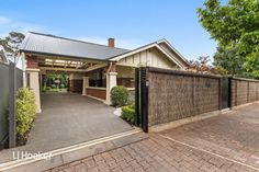 this is an image of a house with a driveway and fence in front of it