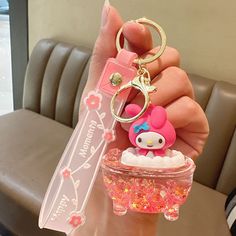 a person holding a hello kitty keychain in their hand