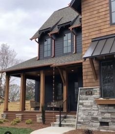 a house that is made out of wood and has stone steps leading up to the front door