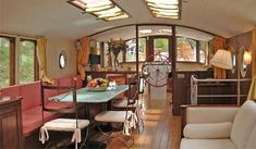 the inside of a house with lots of windows and wood flooring, including couches