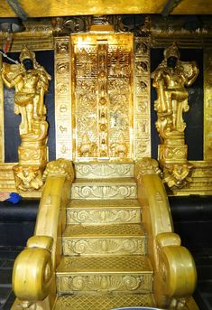 golden steps leading up to an elaborately decorated room with statues on the walls and floor