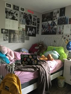 a bed with lots of stuffed animals and pictures on the wall above it in a bedroom