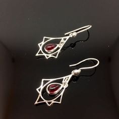 "Art Deco lovers rejoice! Here are red Garnet earrings in Sterling silver! So often we see Art Deco designs that are only red and gold but I also make Garnet and silver jewelry in Art Deco inspired designs. These sweet earrings are lightweight and easy to wear. The deep red Garnet gemstones smooth cabachons that are bezel set in Sterling silver that dangle freely in a Sterling Art Deco charm. They hang 1.5 inches on Sterling silver ear wires with a sterling accent. These also make a wonderful gi Elegant Round Earrings With Artistic Design, Sterling Silver Teardrop Jewelry With Artistic Design, Artistic Sterling Silver Teardrop Earrings, Artistic Dangle Jewelry As Gift, Artistic Dangle Jewelry For Gifts, Artistic Design Dangle Jewelry Gift, Silver Teardrop Earrings With Artistic Design, Red Teardrop Garnet Earrings, Red Garnet Earrings Gift