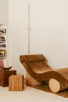 a living room with white walls and wooden furniture on the floor in front of a bookshelf