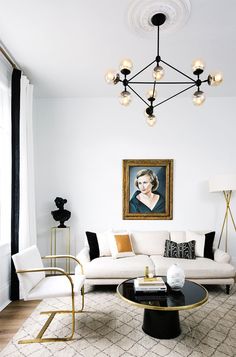 a living room filled with furniture and a painting on the wall above it's coffee table