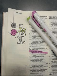 two pens sitting on top of an open bible with the words, my joy comes from the lord