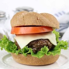 a hamburger with lettuce, tomato and cheese