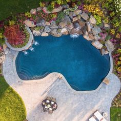 an aerial view of a swimming pool surrounded by landscaping