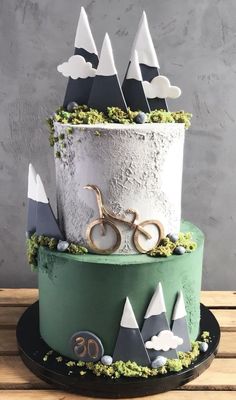 a cake decorated with mountains, trees and a bike