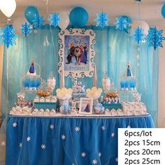 a table topped with lots of desserts and balloons in front of a blue curtain