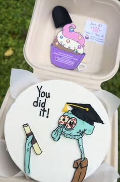 an odd shaped cake with a graduation cap on it's head and the words you did it