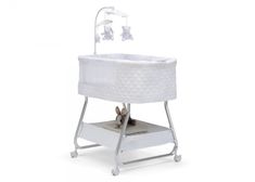 a white baby crib with a cat in it