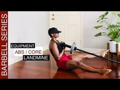 a woman is sitting on the floor with an exercise equipment in her hand and holding a bar